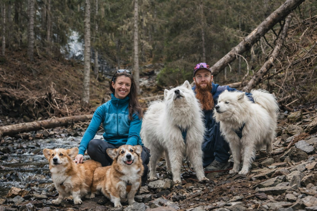 couple and dogs by rocky stream